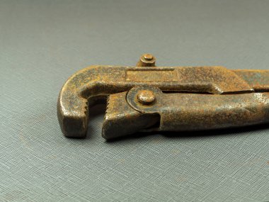 Koyu gri arka planda paslı bir tesisatçı anahtarı..