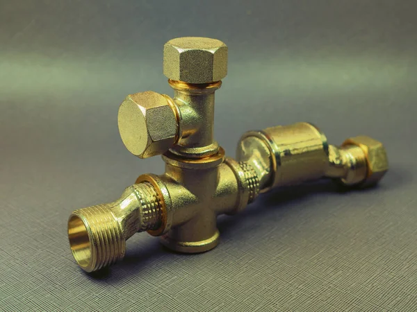 The bronze plumbing equipment for gas and water pipes  on the dark  background.