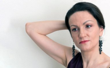 Beyaz duvarın önündeki düşünceli beyaz kadın portresi..