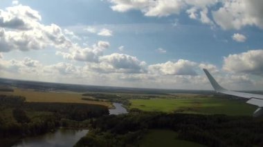 Ticari uçakla rüzgârlı bir yaz gününde yaklaşın ve yere inin. Uçak penceresinden bak. Yolcu görüntüsü. 2020 Yazı.