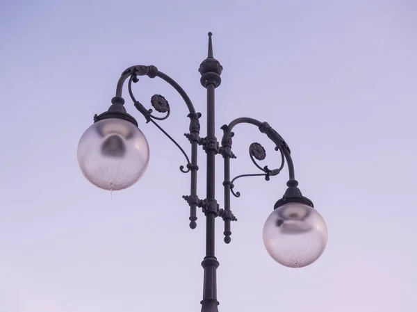 Vintage street lamp against the background of the early evening sky.
