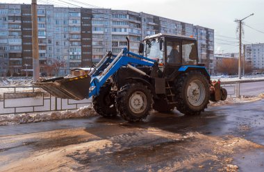 Traktör baharda kaldırımda kar temizliyor..