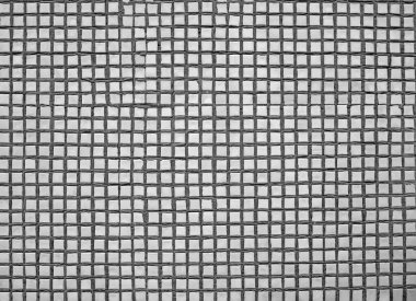 Küçük beyaz fayanslardan oluşan bir desen. Kaba eski duvar yüzeyinin dokusu. Yakın plan..