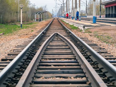 Demiryolu pisti. Bir yolcu platformu. Trans-Sibirya Demiryolu 'nun 4106. kilometresi. Banliyö trenini bekleyen tanınmayan insanlar..