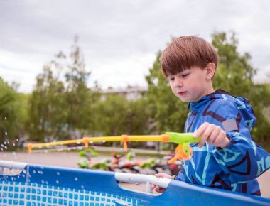 8 yaşında beyaz bir çocuk kürek havuzunda balık avlıyor. Boş zaman aktivitesi. Oynayan çocuk..