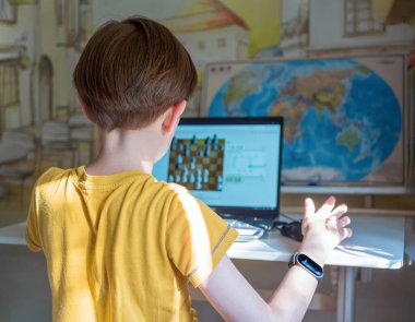 Beyaz çocuk dizüstü bilgisayarla internet satranç turnuvasına katılıyor. Satranç oyunları.