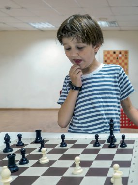 Çocuk satranç okulunda incelikle satranç oynuyor..
