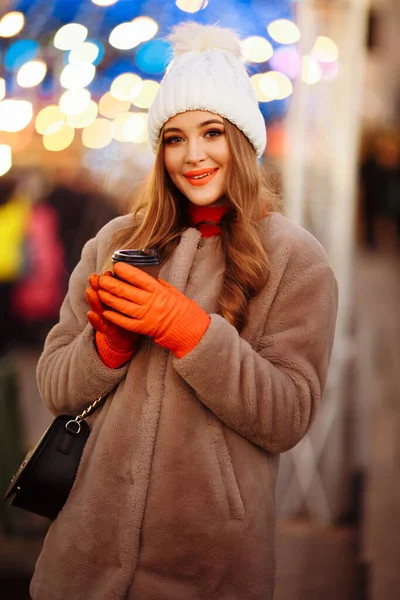 コーヒーと光の背景にある美しい女の子通り休日新年 夜の街を歩くと笑顔になり — ストック写真