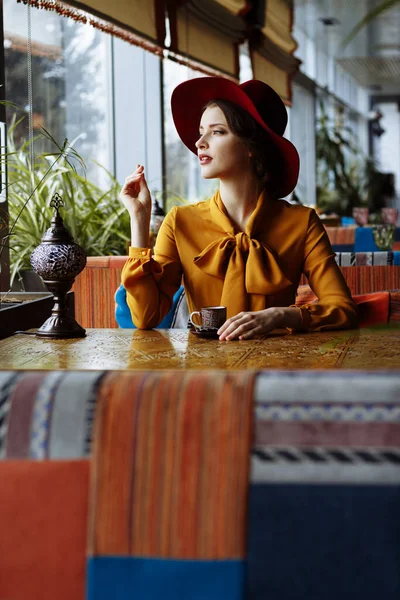 Дівчина в жовтій сукні і капелюх сидить в кафе, пандемія, ізоляція . — стокове фото