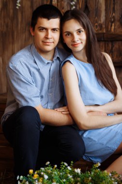 Adam bir kıza sarılıyor, gülümsüyor, aşık çift, mavi elbise ve gömlek. Tarih, Sevgililer Günü,