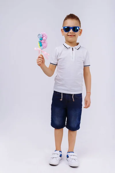 Хлопчик Сонцезахисних Окулярах Джинсових Шортах Білій Футболці Білому Тлі Тримає — стокове фото