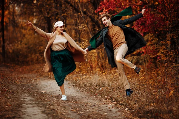 Casal apaixonado ri e caminha na queda no parque, na floresta, folhas amarelas. reunião e data. primeiro amor. — Fotografia de Stock