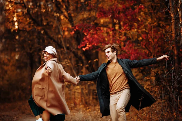 Couple in love laughs and walks in the fall in the park, in the forest, yellow leaves. meeting and date. first love. — Stock Photo, Image