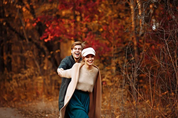 Couple in love laughs and walks in the fall in the park, in the forest, yellow leaves. meeting and date. first love. — Stock Photo, Image