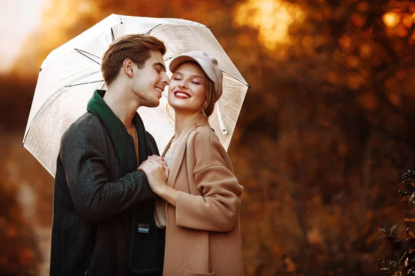 Coppia innamorata che si abbraccia in autunno sotto un ombrello — Foto Stock