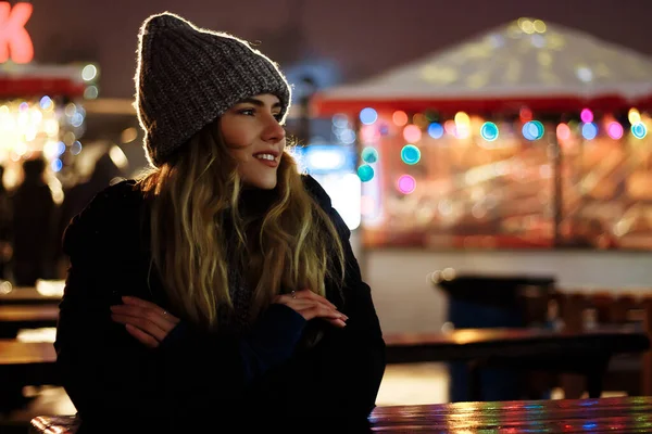 Bella ragazza in cappello invernale vicino all'albero di Natale, vacanze invernali, vacanze e passeggiate foto sotto una fotografia di film con grano Fotografia Stock