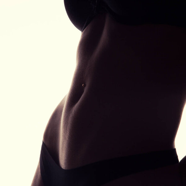 Crop photo of perfect female belly with piercing