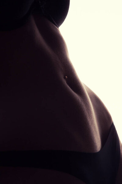 Crop photo of perfect female belly with piercing