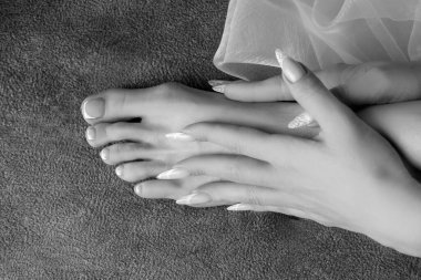 Ayak, yalın ayak pedikür ve manikürlü el.