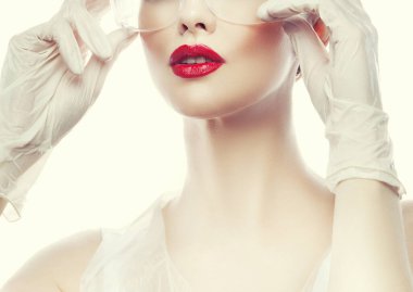 Kırmızı dudaklar. Güzellik uzmanı kadının çekici bir fotoğrafı. Doktor üniforması giyiyor.