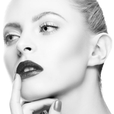 Güzellik. Parlak makyajlı, mükemmel sağlıklı ciltli genç bir kadının yüzü. Dudakların yanında el ele tutuşun.