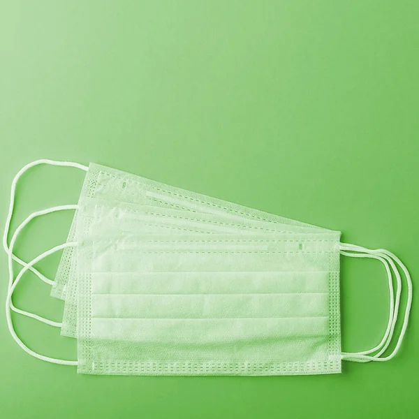 Medical mask surgical protective virus, flu, disease, textile filter. Isolated on a green background.