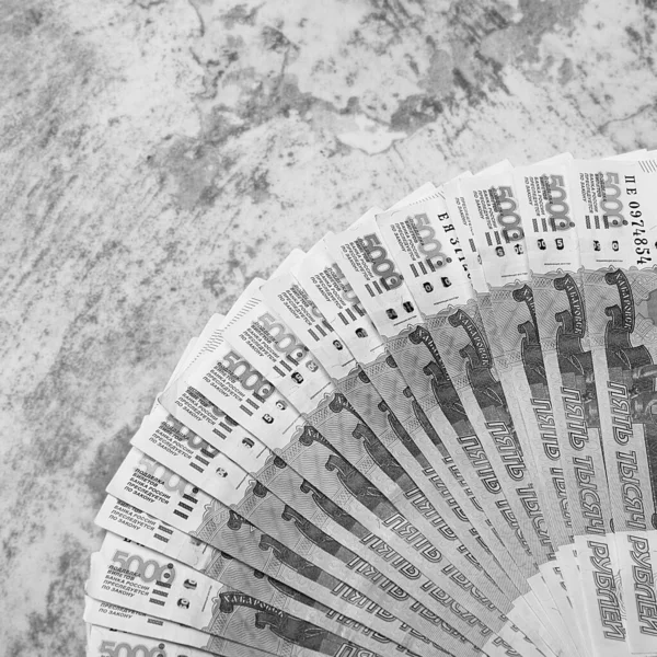 Russian money banknotes of five thousand rubles, background, banknotes are arranged in a fan on a gray background. Layout, mockup.