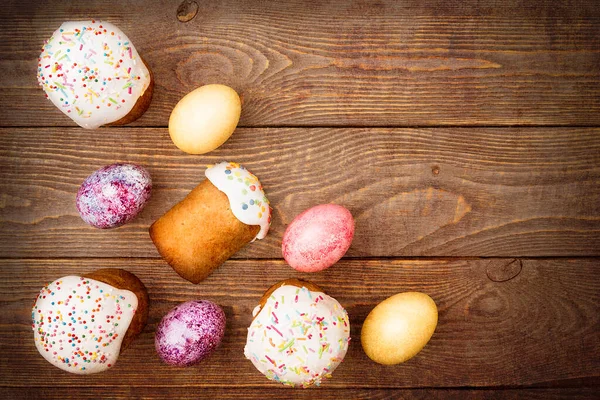 Easter cakes and Easter colored eggs on a wooden background. Religious holiday of bright Easter.