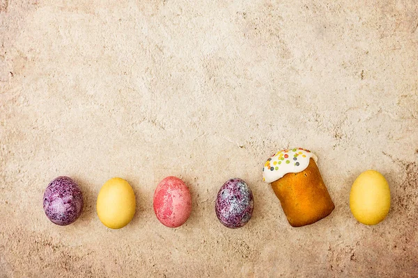 Easter cakes and Easter colored eggs on a beautiful textured background. Religious holiday of bright Easter.