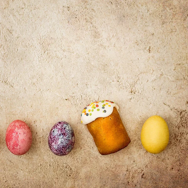 Easter cakes and Easter colored eggs on a beautiful textured background. Religious holiday of bright Easter.