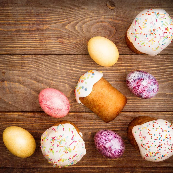 Easter cakes and Easter colored eggs on a wooden background. Religious holiday of bright Easter.