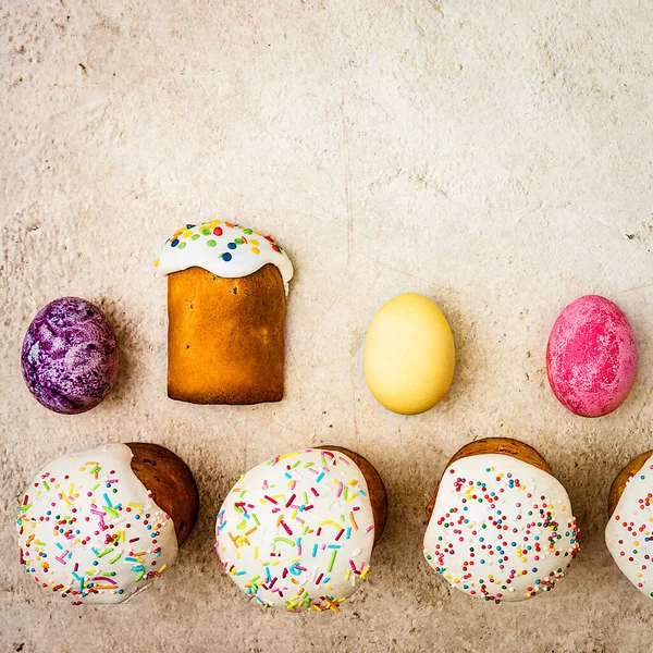 Easter cakes and Easter colored eggs on a beautiful textured background. Religious holiday of bright Easter.