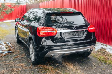MOSCOW, RUSSIA-NOVEMBER 26, 2020: siyah Mercedes Benz GLA 250, sonbahar arka planında egzoz borularından çıkan dumanla, dikiz manzarası.