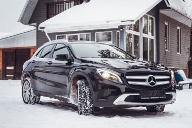Siyah lüks Mercedes Benz GLA Kış mevsiminde bir banliyö arazisinde 250.