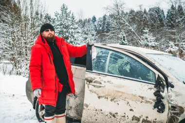 Kazadan sonra bir adam kaza yapmış bir arabanın kapısını tutar., 