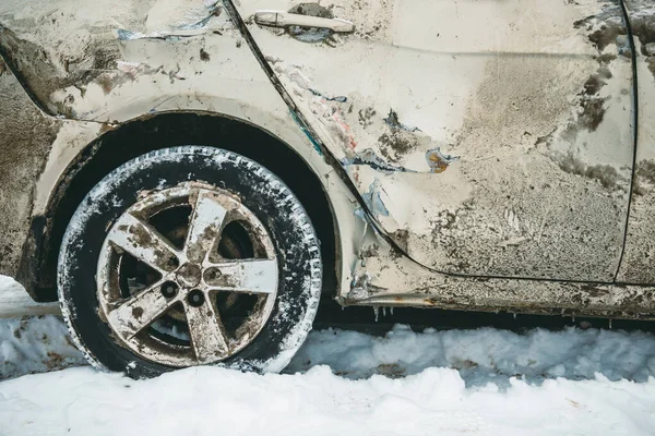 The car overturned on a snowy road and got on its wheels. Close-up of the wheel of a broken car after an accident that flew off the road at high speed.