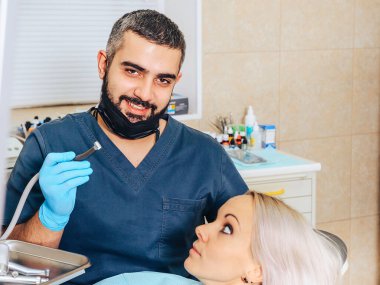 Neşeli, gülümseyen bir dişçide, korkmuş sarışın bir kız..