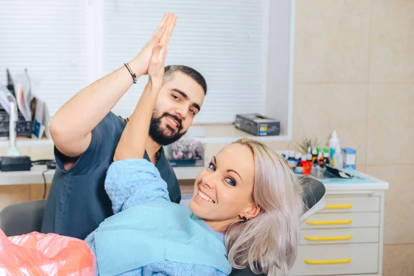 Gülümseyen kız, dişçi koltuğundaki erkek dişçinin resepsiyonunda..