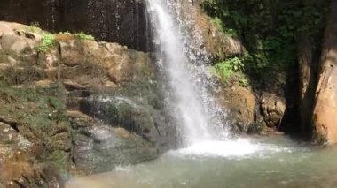 Güneşli bir günde, bir dağ nehrinde şelale.
