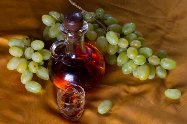 Decanter of brandy and grape — Stock Photo, Image