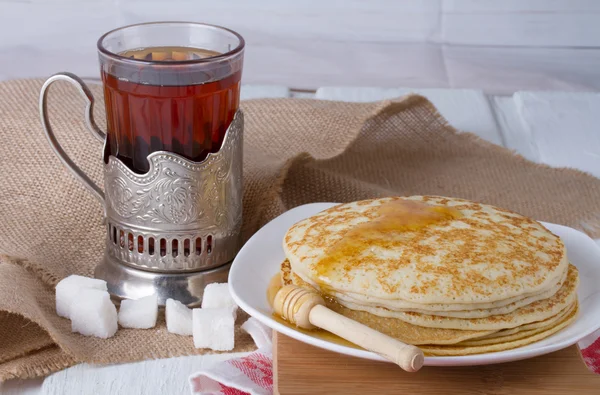 Traditional Russian meal - pancakes with honey and sweet tea — Stock Photo, Image