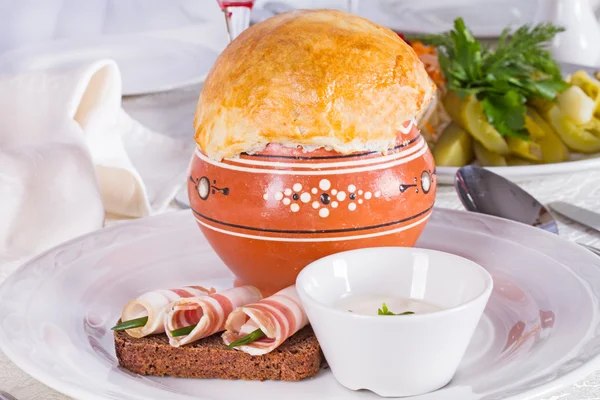 Russian cabbage soup in a clay pot baked under a layer of dough — Stock Photo, Image