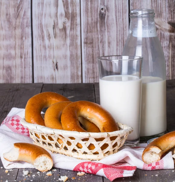 Leche y rosquillas sobre una mesa de madera — Foto de Stock