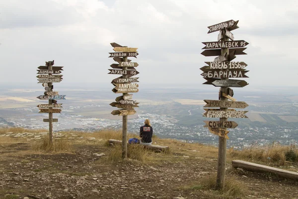 Ponteiros distâncias para diferentes cidades e turistas no topo do Monte Mashuk — Fotografia de Stock