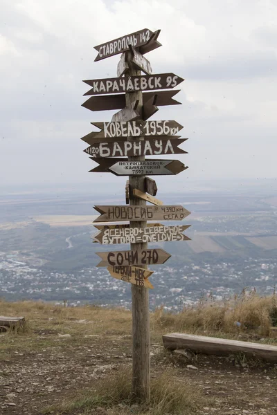 Indicadores de distancias a diferentes ciudades y turistas en la cima del Monte Mashuk —  Fotos de Stock