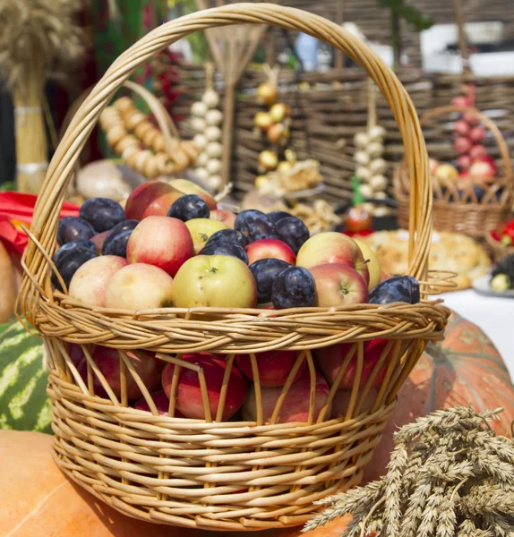 Basket with red apples and plums — Stock Photo, Image