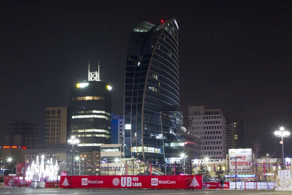 ULAANBAATAR, MONGOLIA - 2 DE FEBRERO: Pista de patinaje en la Plaza Sukhbaatar y vistas al hotel Blue Sky en la noche del 2 de febrero de 2015 en Ulan Bator . —  Fotos de Stock