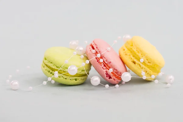 French multicolored macaroon cookies entwined with pearl beads — Stock Photo, Image