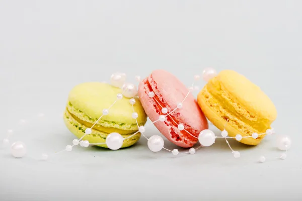 French multicolored macaroon cookies entwined with pearl beads — Stock Photo, Image