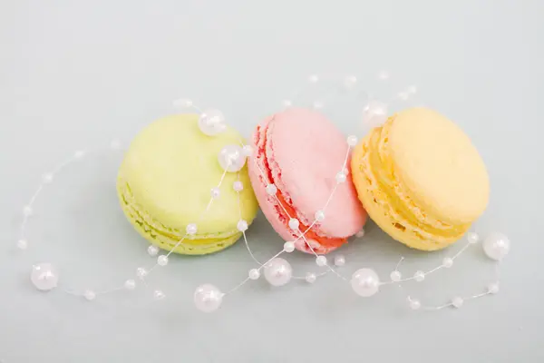 French multicolored macaroon cookies entwined with pearl beads — Stock Photo, Image